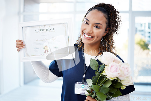 Image of Certificate, rose and portrait with a black woman graduate in the hospital, proud of her achievement. Smile, graduation and qualification with a happy young female nurse standing alone in a clinic