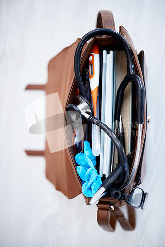 Image of Top view, doctor bag and clinic with stethoscope, books and glasses on desk for job in medical industry. Doctors, nurse or medic tools in leather case for healthcare, wellness and help at hospital