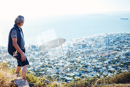 Image of Hiking, explore and senior man with city view for on an adventure, workout and fitness in Cape Town. Training, exercise and elderly person trekking on a mountain for health and wellness