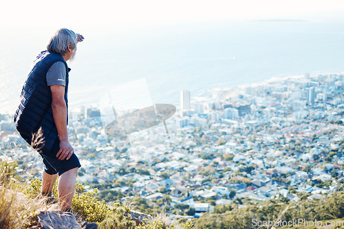 Image of Hiking, looking and senior man explore a city view for on an adventure, workout and fitness in Cape Town. Training, exercise and elderly person search on a mountain for health and wellness