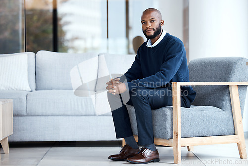 Image of Psychologist, waiting and black man sitting on chair at work, job or modern workplace in modern office lounge. Portrait, employee and African American businessman or therapist with positive mindset