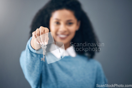 Image of Black woman, hands and key for real estate, new home or property against a gray studio background. Hand of happy African American female holding keys for rent, building loan or investment on mockup