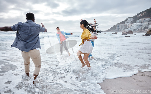 Image of Friends at beach, water splash and ocean with travel and adventure, group of people have fun on holiday. Diversity, playful and nature, social get together and laugh, freedom outdoor in Los Angeles