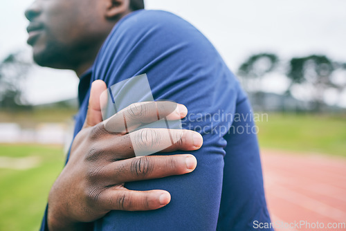 Image of Sports, hands and black man with pain in arm from exercise, workout and marathon training in stadium. Fitness, runner and athlete with joint strain, body injury and medical emergency on running track