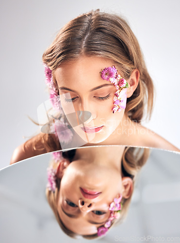 Image of Beauty face, mirror reflection and woman with flower product, sustainable agriculture and natural skincare. Facial makeup, nature plant cosmetics and eco friendly girl isolated on studio background