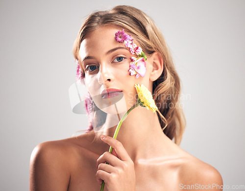 Image of Beauty, flower and portrait of woman in studio with a skincare, natural and face routine. Floral, health and female model with organic, self care and fresh skin or facial treatment by gray background