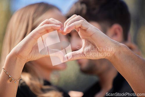 Image of Happy, heart shape and couple hugging in nature while on romantic date for valentines day or anniversary. Intimacy, affection and young man and woman embracing with love hand sign or gesture together