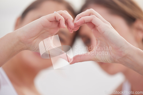 Image of Heart hands, couple of friends and women outdoor with blurred background showing teamwork. Love, care and support hearts emoji hand sign of lgbt pride and solidarity together for valentines day