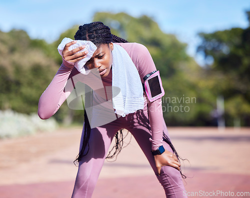 Image of Sweat, exercise and black woman outdoor, tired and running for wellness, balance or cardio. African American female athlete, runner and lady with towel, rest or break after workout, training or relax