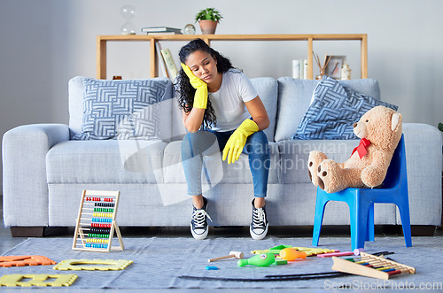 Image of Tired, cleaning and black woman in living room with chaos and stress from toys at home. Cleaner, stress and burnout from housekeeping work on a lounge couch ready for sleeping from anxiety and mess