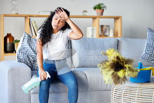 Image of Tired woman, housekeeper and detergent on sofa in the living room for cleaning, hygiene or disinfection at home. Exhausted female maid or cleaner in burnout, stress or fatigue for routine maintenance