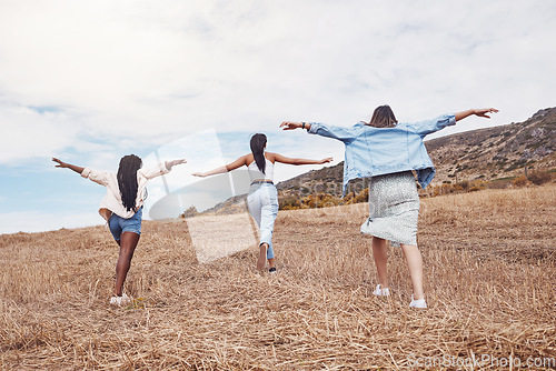 Image of Freedom, nature and friends running together outdoor for adventure, fun or exploring the wilderness. Run, autumn and excited with a woman friend group playing outside while bonding from the back