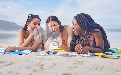 Image of Girl friends, beach and phone of a teenager laughing at funny meme by the sea in Miami. Travel, vacation and sunshine with happy students enjoying spring break with mobile connection lying on sand