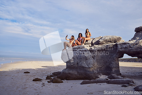 Image of Friends, beach and selfie for diversity on a rock outdoor for holiday or vacation in summer. Group of women together at sea or ocean for travel in Bali for freedom in nature with water and blue sky