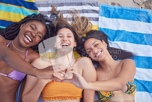 Image of Friends, beach and women with heart for love and support on vacation, travel or holiday in summer. Above group together on towel for tropical, funny or comic time together with diversity and hands