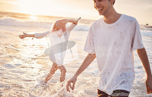 Image of Couple at beach, splash in water with ocean, travel and freedom outdoor, love and care in relationship with youth. Cafe free at sunset, nature and sea waves with young people on holiday in Hawaii