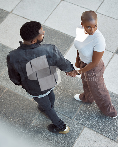 Image of Top view, love and couple holding hands in city while walking in the street on holiday. Intimate, relationship and young African man and woman on romantic walk in the town road together on vacation.