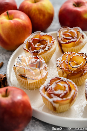 Image of Freshly baked apple roses cakes served on white plate, flat lay