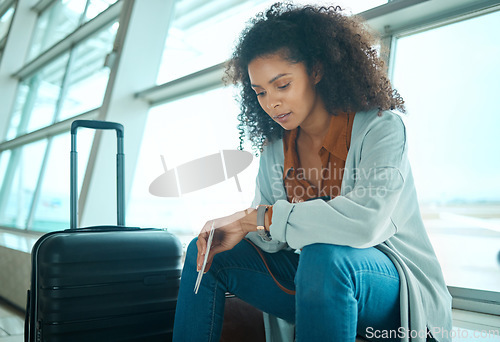 Image of Airport, black woman and watch time check of a young female at plane terminal with flight delay. Waiting, sitting and person with passport document looking at smartwatch for board and transport info