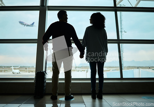 Image of Silhouette, travel and holding hands with couple in airport for departure, flight and vacation break. Shadow, holiday and tourism with man and woman by window for journey, international and boarding