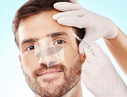 Image of Portrait, man and needle for cosmetics, dermatology and beauty on blue studio background. Face, male and gentleman with skincare, injection and plastic surgery with botox, gloves and facial change