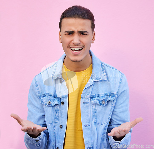 Image of Confused, annoyed and portrait of a man in a studio with a doubt, upset and moody facial expression. Angry, mistake and male model doing sign language or hand gesture isolated by a pink background.
