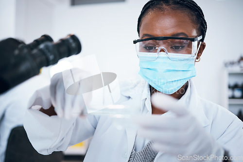 Image of Science, covid and solution with a black woman doctor working in a laboratory for research or innovation. Medical, analytics and development with a female scientist at work in a lab for chemistry