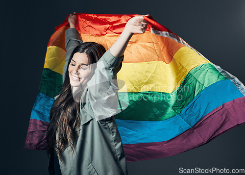 Image of Flag, pride and happy woman, lgbtq and freedom to love, inclusion and equality, protest for human rights. Gay, trans and lesbian, politics and identity with community and rainbow on studio background