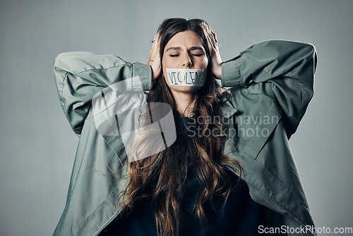Image of Woman, protest and tape on mouth in fear for cold war, armageddon or doomsday against gray studio background. Female activist with hands on head and message to stop or end global violence in society
