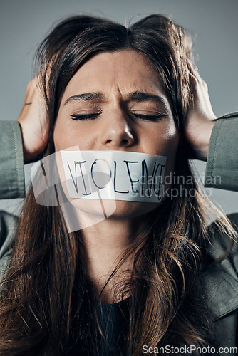 Image of Woman, protest and tape on mouth in fear for cold war, armageddon or doomsday against a gray studio background. Female activist face with hands on head and message to stop or end global violence