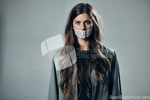 Image of Woman, protest and tape on mouth for inflation, economic change or financial crisis against gray studio background. Portrait of female activist with message to end government greed or taxes on mockup