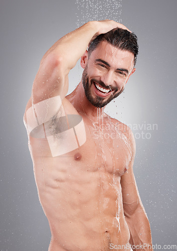 Image of Shower, cleaning and portrait of man with water on gray background for wellness, grooming and beauty. Skincare, bathroom hygiene and male smile for washing body, clean face and soap for healthy skin