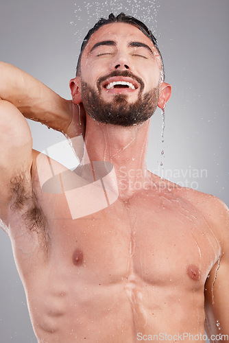 Image of Shower, skincare and man with water in studio on gray background for wellness, grooming and beauty. Cleaning, bathroom hygiene and male smile for washing body, clean face and soap for healthy skin