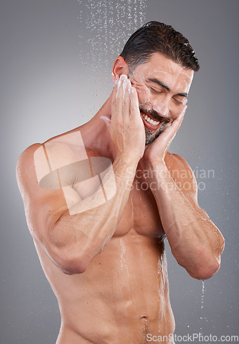 Image of Shower, cleaning and man with water in studio on gray background for wellness, grooming and beauty. Skincare, bathroom hygiene and male smile for washing body, clean face and soap for healthy skin