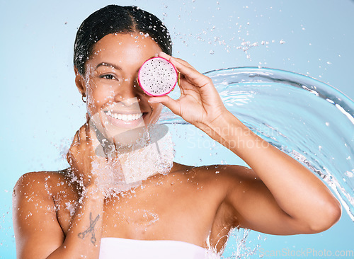 Image of Dragon fruit, beauty and skin care woman portrait for healthy skin and diet on a blue background. Face of aesthetic model person with water splash and food for sustainable facial health and wellness