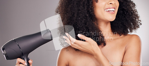 Image of Hair care, beauty and black woman with hairdryer in studio isolated on gray background. Curly haircare, aesthetic or happy female model with machine to dry hairstyle after salon treatment for growth.