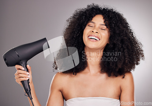 Image of Face, beauty and black woman with hair dryer in studio isolated on gray background. Haircare, aesthetic or happy female model with machine to dry hairstyle after salon treatment for growth or texture