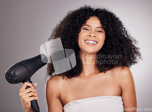 Image of Beauty, portrait and black woman with hair dryer in studio isolated on gray background. Haircare, face and happy female model with machine to dry hairstyle after salon treatment for growth or texture