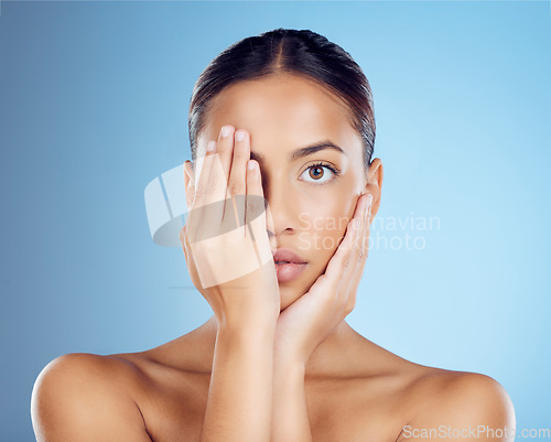 Image of Portrait, hands and woman cover face for beauty, studio and skincare cosmetics on blue background. Female model, facial and dermatology transformation of healthy aesthetic, laser and natural shine