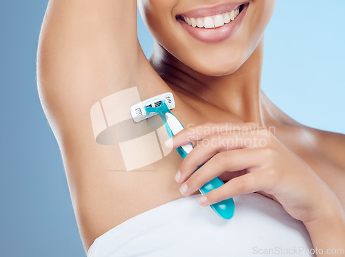 Image of Hand, beauty and shaving with a black woman in studio on a blue background for underarm grooming or hygiene. Skincare, razor and hair removal with a female in the bathroom to shave her armpit