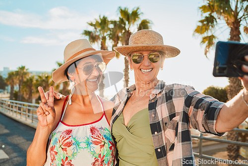 Image of Women, peace selfie and holiday smile in Miami with happiness from summer travel and vacation. Beach, web connection and mobile of mature friends by the sea with happiness on 5g for social media