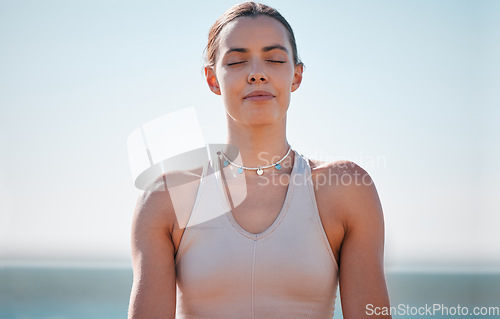 Image of Woman, face and meditation at beach for calm, spiritual freedom and breathe in nature. Young female, zen and eyes closed at ocean for balance mindset, fitness and yoga exercise at sea, relax or peace