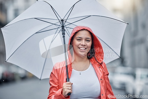 Image of Umbrella, happy and portrait of a woman in the city walking in the rain while on a vacation. Travel, happiness and female with a red jacket on an outdoor walk in town on holiday in black and white.