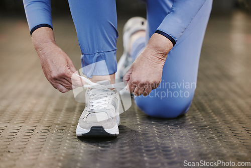 Image of Sports, hands and tie shoes in gym to start workout, training or exercise for wellness. Fitness, athlete health or senior woman tying sneakers or footwear laces to get ready for exercising or running