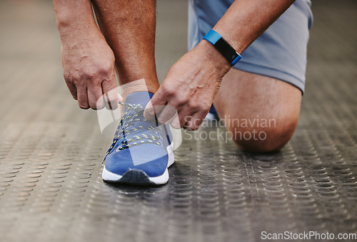 Image of Hands, tie shoes and fitness in gym to start workout, training or exercise for wellness. Sports, athlete and man tying sneakers or footwear laces to get ready for exercising or running for health.