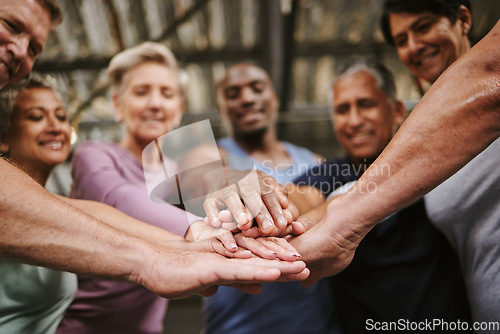 Image of Teamwork, hands together and senior people in gym for motivation, solidarity and team building. Collaboration, group of friends or retired men and women huddle for workout goals and training targets