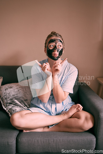 Image of Self love, face mask and relax goofy woman in her home, house or apartment doing morning beauty routine with hand gesture. Portrait, facial and female funny and excited for skincare using charcoal