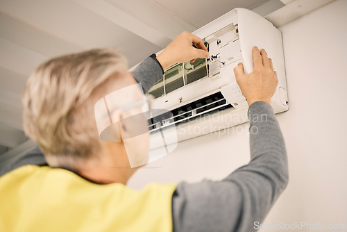 Image of Maintenance, installation and back of a man with air conditioner for service and ac repair. Building, technician and a handyman fitting an appliance on a wall of a home for home improvement and heat