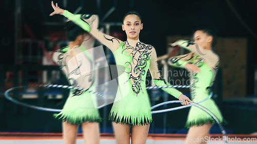 Image of Sports, gymnastics and woman performing with a hula hoop in a studio with a spinning blur motion. Fitness, gymnast and female athlete practicing agility, skill or flexibility for a routine at a gym.