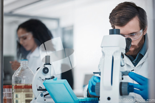 Image of Man, doctor and forensic science with microscope for examination, experiment or test at the laboratory. Male scientist looking at micro organisms for exam, breakthrough or testing to find cure at lab